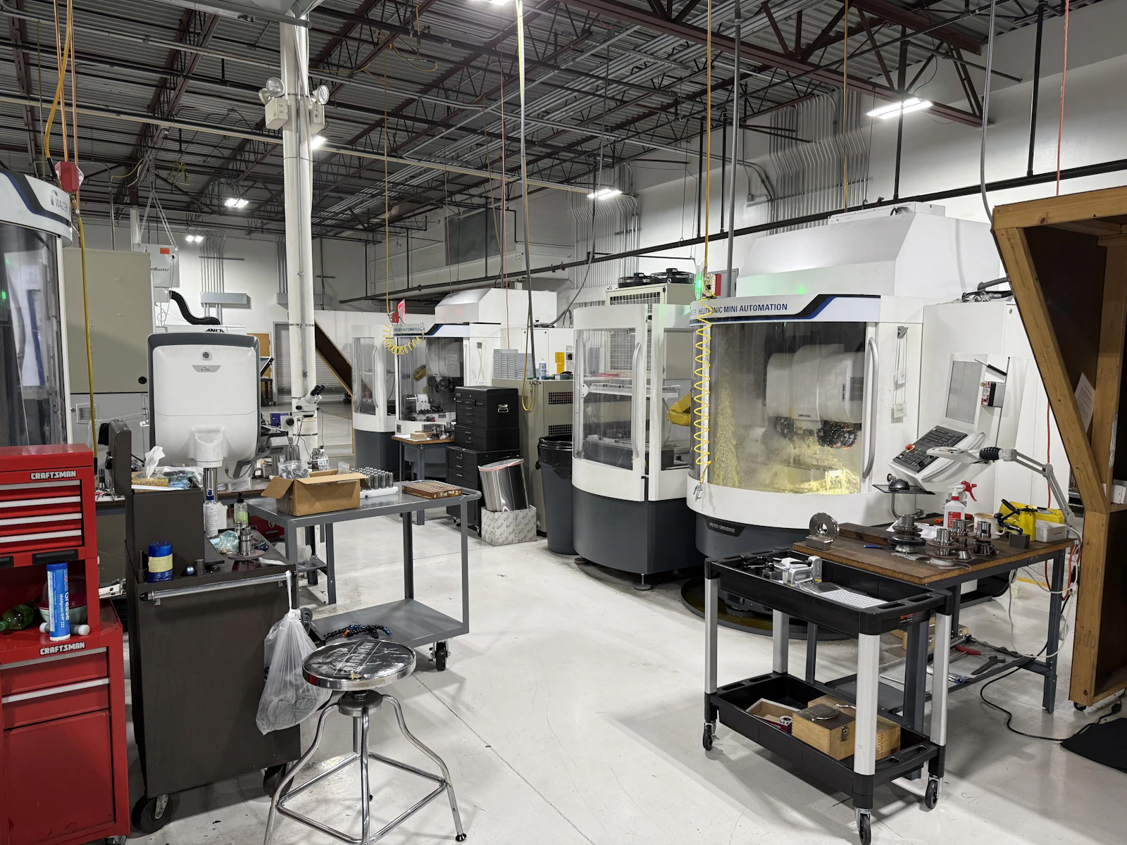 Clean machine shop floor with CNC machines and tool carts